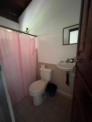 a bathroom with a toilet and a sink at Her Waves & Wi-Fi Boutique Hotel in Tamarindo