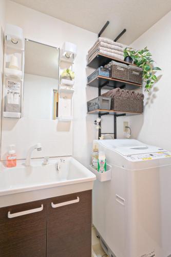 a bathroom with a sink and a mirror at ゲストハウス夢宿 in Osaka