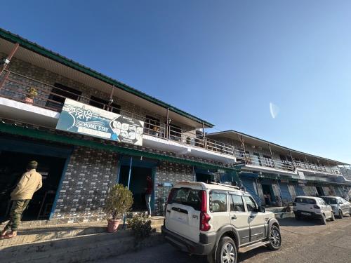 a white suv parked in front of a building at Rudraksh Hotel and restaurant in Amgarhi