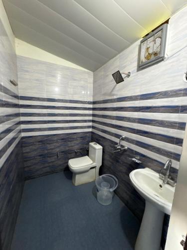 a bathroom with a toilet and a sink at Rudraksh Hotel and restaurant in Amgarhi