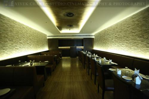 a restaurant with a row of tables and chairs at Dee Marks Airport Hotel & Resorts in New Delhi