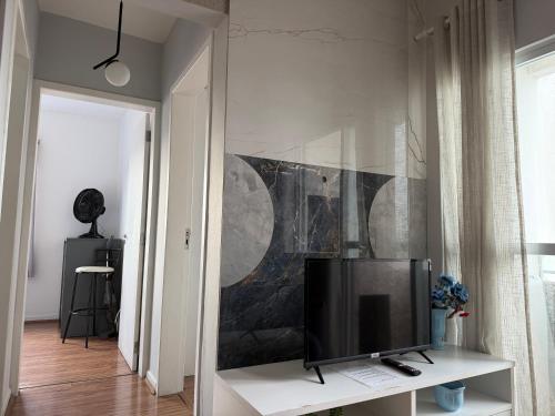 een woonkamer met een televisie op een witte tafel bij Lindo apartamento completo e com garagem coberta in Palhoça