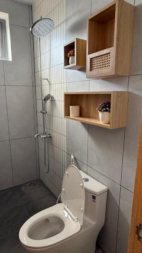 a small bathroom with a toilet and a shower at Moon Hotel Buôn Hồ in Buôn Tring