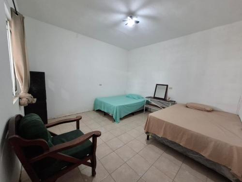 een kamer met 2 bedden en een stoel en een bed bij Casa Fiorella 