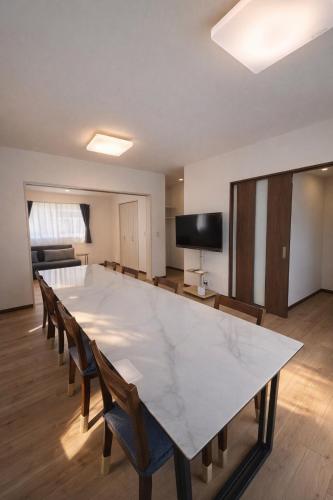 a large white marble table in a room with chairs at Wstay in Ozu