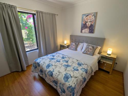 een slaapkamer met een bed en een raam bij Lake Estate Stay in Perth