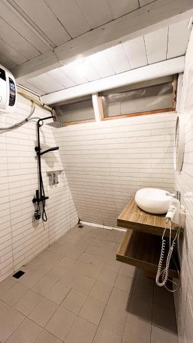 a white bathroom with a sink and a shower at Patria Villa Turi in Soprayan