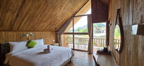 a bedroom with a bed and a large window at Teras Danu in Bedugul