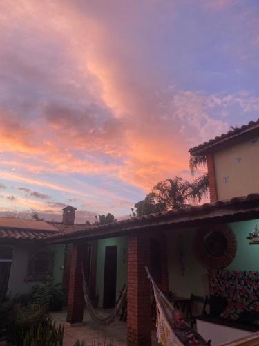 a house with a sunset in the sky at Suíte master - Hostel em Itupeva in Itupeva