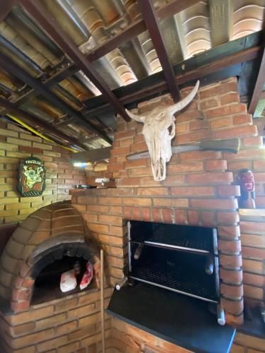 a skull of a deer on the wall of a brick oven at Suíte master - Hostel em Itupeva in Itupeva