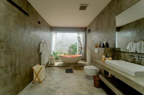 un bagno con vasca, lavandino e WC di Newly Built Villa - Rice Fields & Tranquil Getaway a Tumbak Bayuh