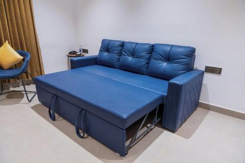 a blue couch in a room with a chair at Nes-Terns in Coimbatore