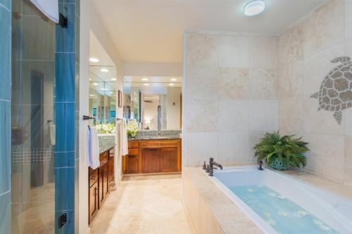 un bagno con vasca, lavandino e doccia di 1712 Kapalua Home a Kahana