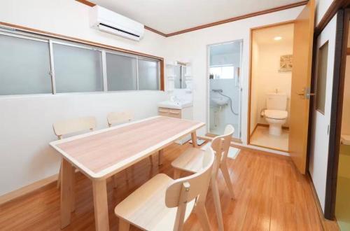 a dining room with a table and chairs and a toilet at Private Tatami House 4min from Teradacho Sta in Osaka