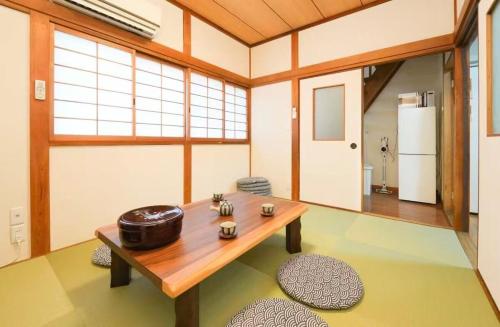 a room with a wooden table and a refrigerator at Private Tatami House 4min from Teradacho Sta in Osaka