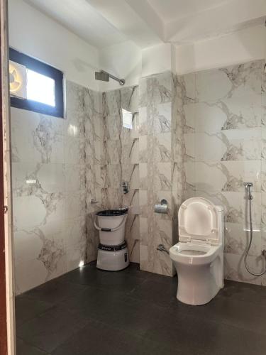 a bathroom with a toilet and a shower at The Blue Mont Sojha Jibhi in Shoja
