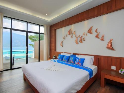 a bedroom with a large bed and a large window at The Green Hotel in Ko Lipe
