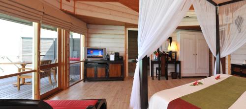 a bedroom with a bed and a television in it at Komandoo Island Resort & Spa in Komandoo