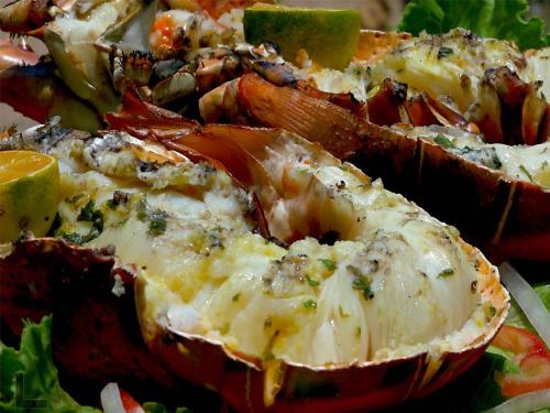 a plate of food withcooked food with cheese and vegetables at Hotel Village Vacances Awale Plage in Grand-Popo