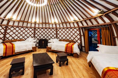 een kamer met 3 bedden in een yurt bij Blue Spot Resort in Yoliin Hural