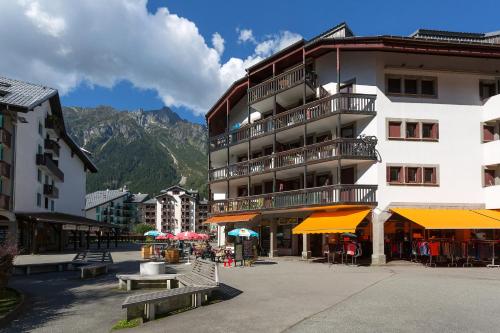 a building with tables and umbrellas in front of it at Apremont in Chamonix-Mont-Blanc