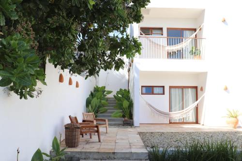 een binnenplaats van een huis met stoelen en een boom bij Casa Aia in Aracaju