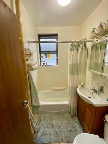 a bathroom with a tub and a toilet and a sink at Woodside room in Sunnyside