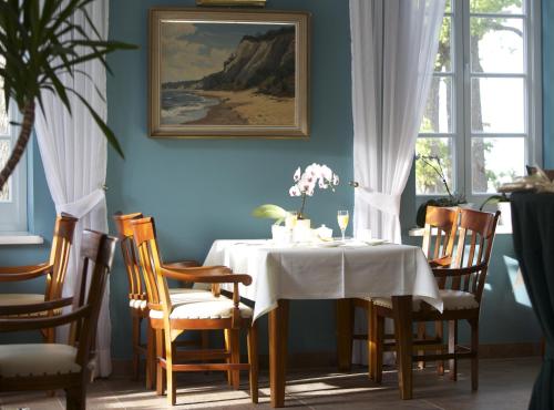 een eetkamer met een witte tafel en stoelen bij Hotel Badehaus Goor in Putbus