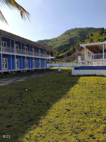 a row of buildings with a grass field in front at The houmstay pangsing in Mataram