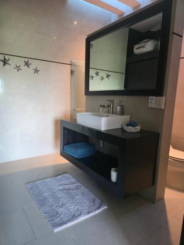 a bathroom with a sink and a tv above it at Casa Flamingos Coco in Mezcales