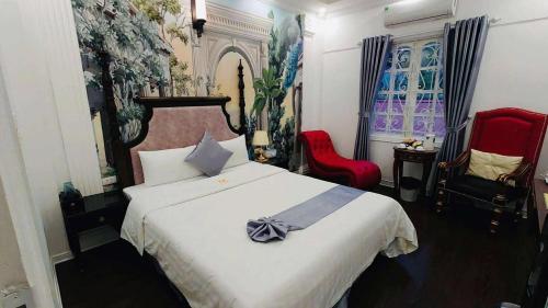 a bedroom with a bed and two red chairs at Khách sạn Đặng Anh in Hanoi