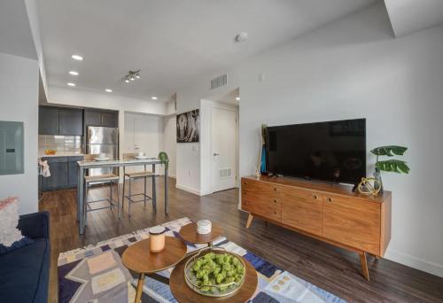 a living room with a flat screen tv on a wooden entertainment center at Luxe on Hollywood Blvd 2BR with FREE PARKING in Los Angeles