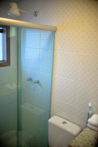a bathroom with a glass shower and a toilet at Pousada e Restaurante O Pescador in Abraão