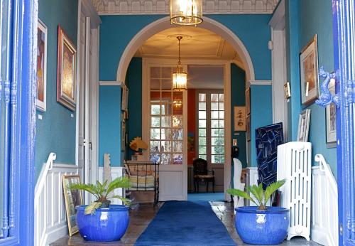 a hallway with blue walls and potted plants at chambres de charme "Florence" in Ribérac