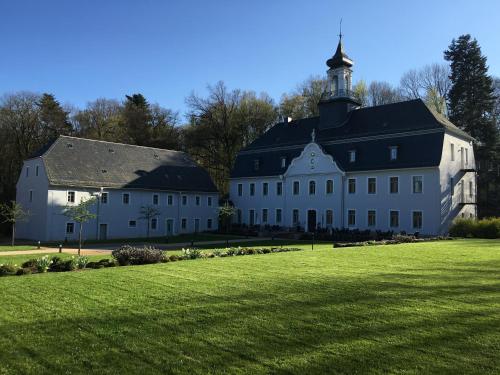 ein großes weißes Gebäude mit schwarzem Dach in der Unterkunft Hotel Schloss Rabenstein in Chemnitz