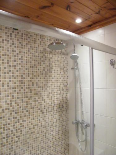 a shower in a bathroom with a tile wall at Nocturne Family House in Paola