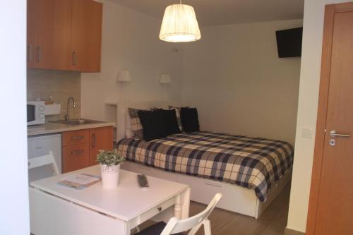 Habitación pequeña con 1 cama con mesa y cocina en Isaura Home, en Peniche