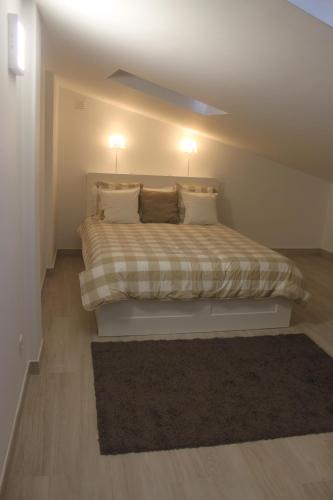 a bedroom with a bed with two lights on the ceiling at Isaura Home in Peniche