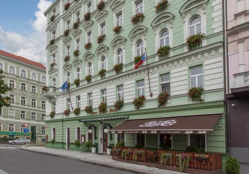 un gran edificio con banderas en una calle en Green Garden Hotel en Praga