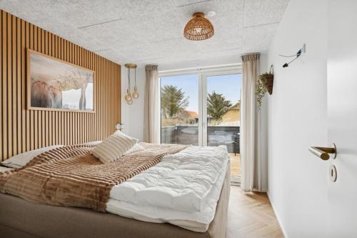 a bedroom with a large bed and a large window at Feriehus 1147 in Ringkøbing
