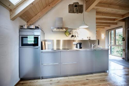 a kitchen with stainless steel appliances and wooden ceilings at Basalt-Loft in Kottenheim