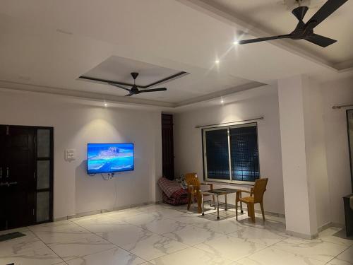 een woonkamer met een tafel en een tv aan de muur bij Fortress Homestay in Yavluj