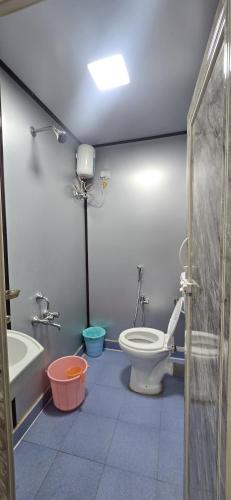 a bathroom with a toilet and a bath tub at Nishatana Farm Stay in Bangalore