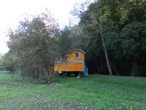 a small orange house in a field with trees at B&B Le Danica in Dordives