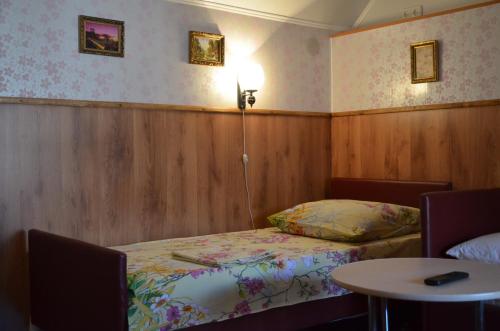 クルィヴィーイ・リーフにあるCottages On Gdantsevskaya Streetのベッドとテーブル付きの小さな部屋