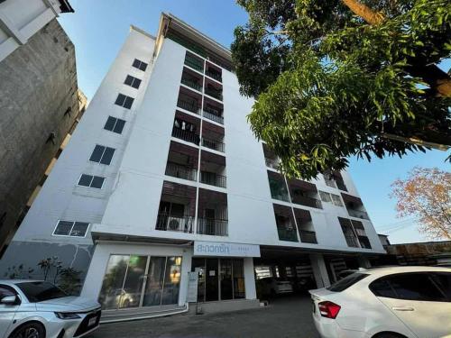 a white building with a car parked in front of it at Chiang Mai view place in Ban Hua Phrong