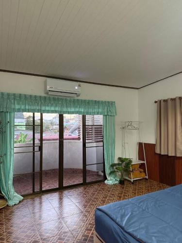 a bedroom with a bed and a large window at The Warm House in Ban Komo Sip Paet