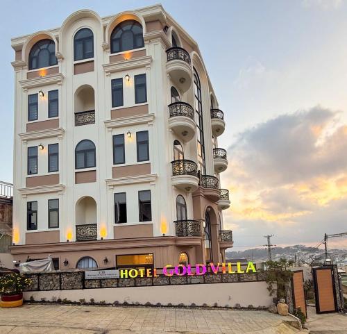 a large white building with a sign on it at Gold Villa in Trai Mat