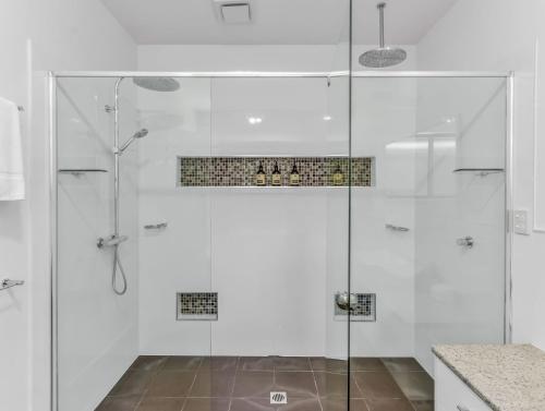 een douche met een glazen deur in een badkamer bij Lennox Coastal Retreat - resort-style home w. pool in Lennox Head