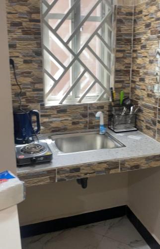 a kitchen sink with a window above it at Mnazinisky B&B in Zanzibar City